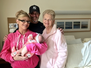 new mom, dad and grandma holding newborn baby